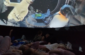 Uczniowie klasy I, II oraz dzieci z oddzialu przedszkolnego w kinie sferycznym