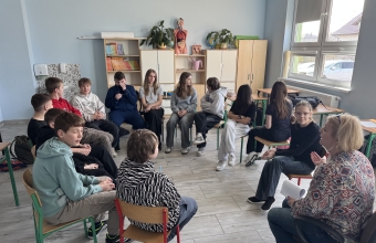 Uczniowie klasy siodmej siedzacy w kregu podczas trwania warsztatow profilaktycznych